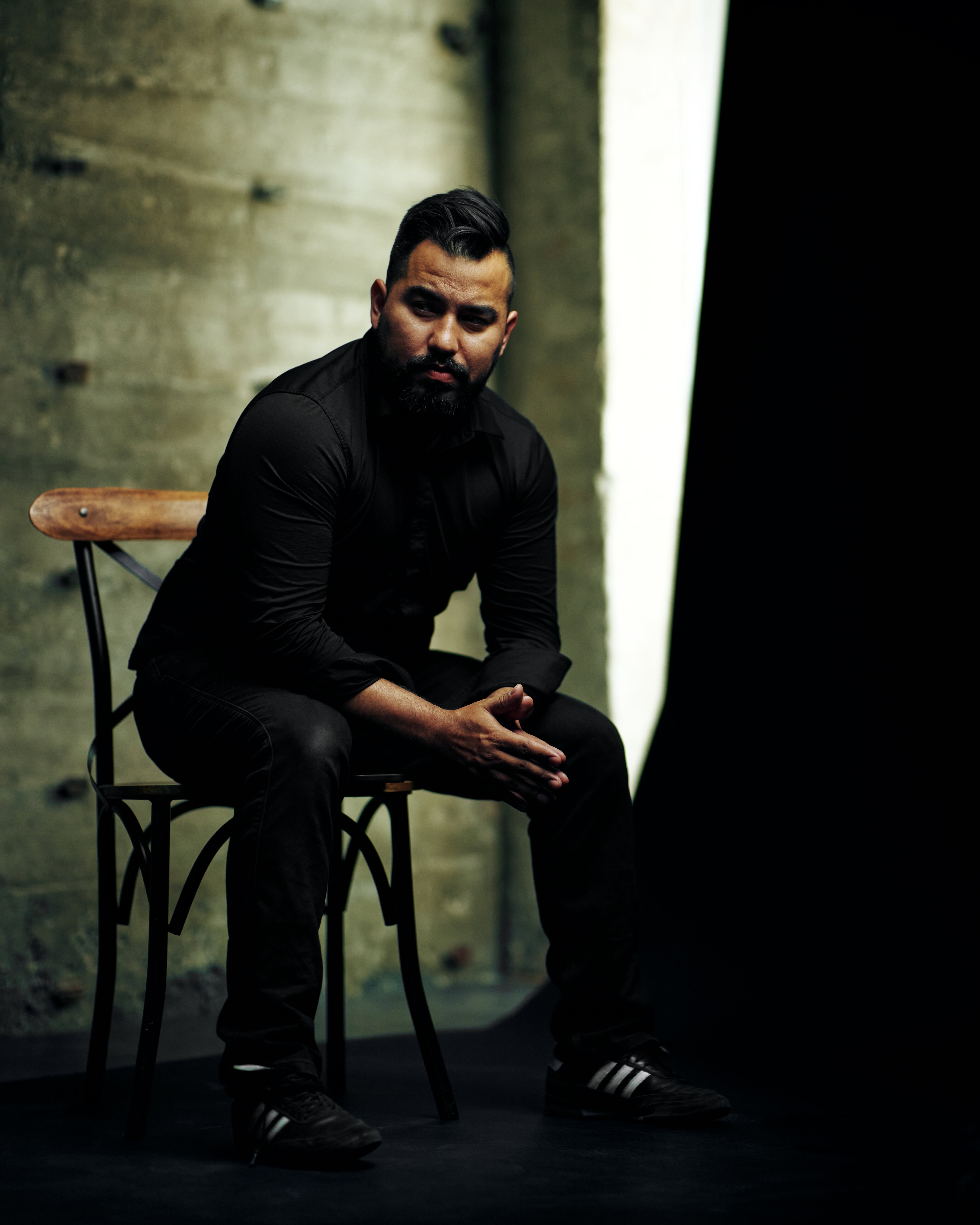 Calgary corporate headshot of a man sitting on a chair in a studio.